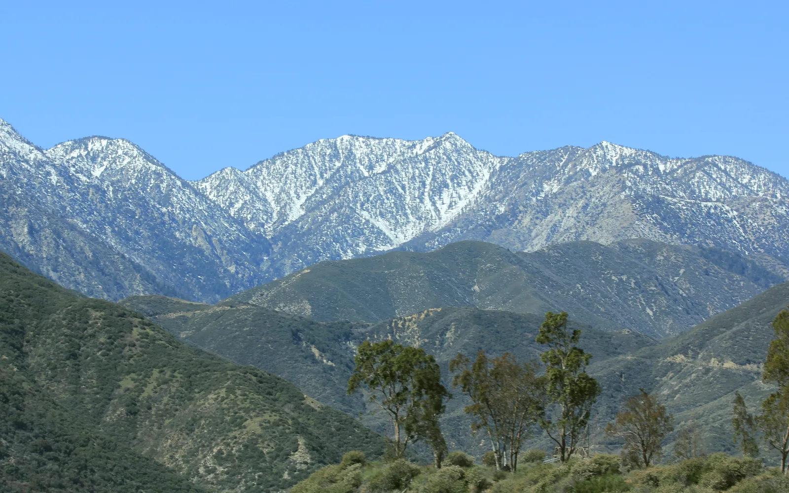 A panoramic view of the San Gabriel Mountains with desert landscape in the foreground